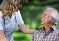 Smiling nurse with man in wheelchair